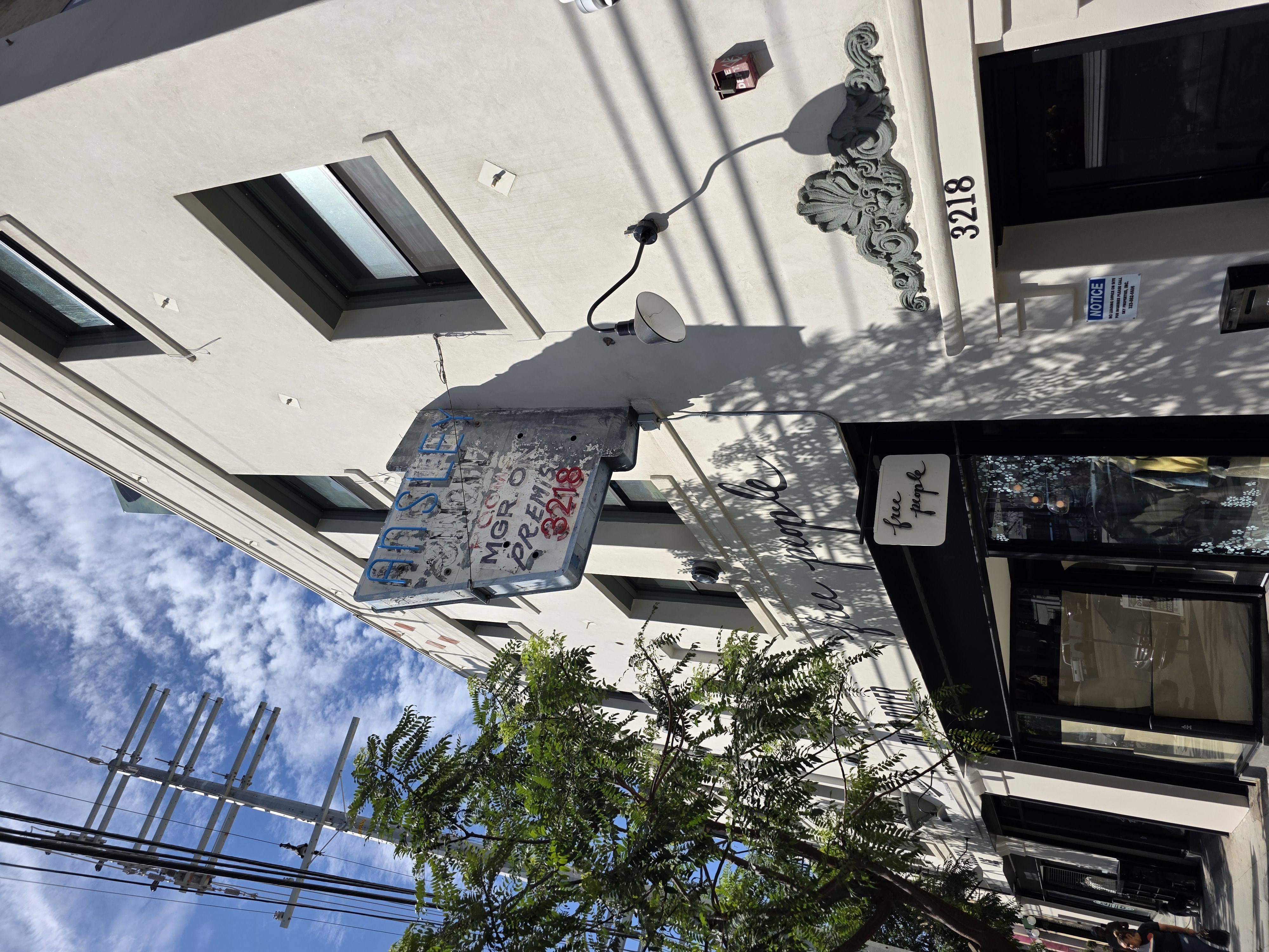 Outside an old building with 1940's original neon light and hand painting on it for rented rooms, above the business Free People on Silver Lake Blvd