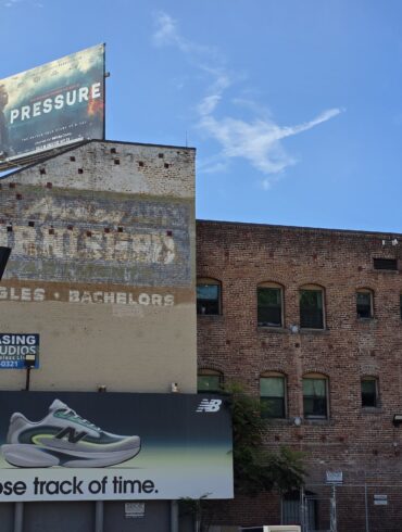 Outside Sunset Row Sign with an old brick building