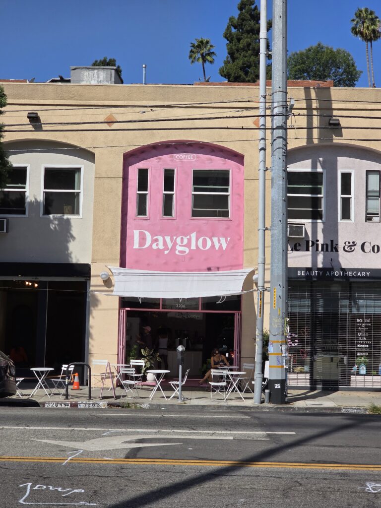 Day Glo restaurant in Silver Lake with bright pink painted building with patrons outside on small bistro tables