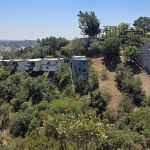 View of a canyon in Mt. Washington with cantilevered homes jetting up from the hillside and solar panel farm in the distance