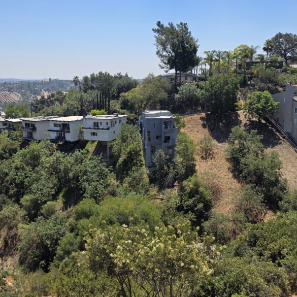 View of a canyon in Mt. Washington with cantilevered homes jetting up from the hillside and solar panel farm in the distance