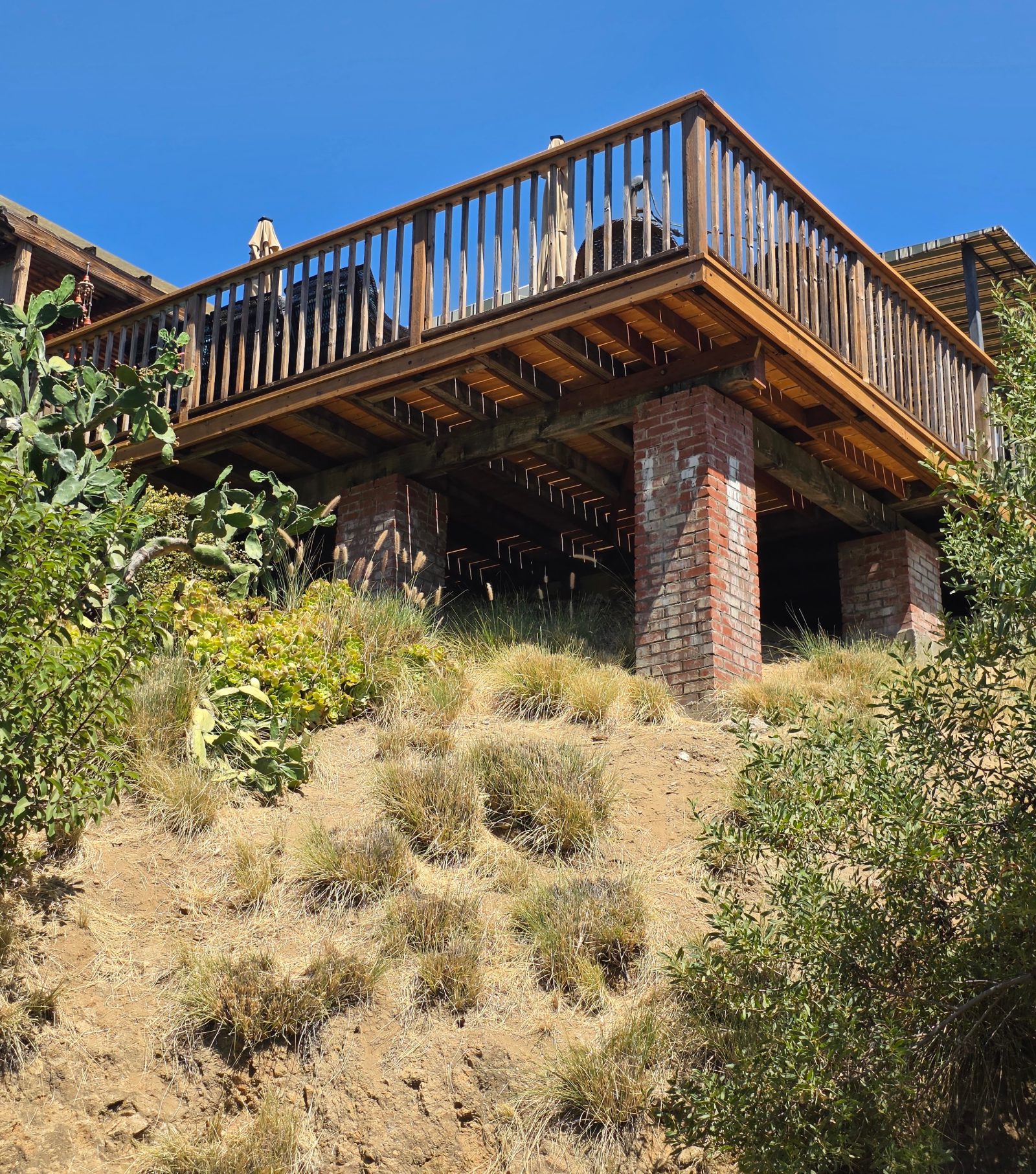 Wood deck on brick piers above a dry grassy hillside in Eagle Rock, Los Angeles